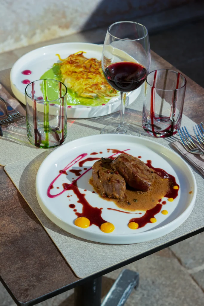 Piatto di carne con salsa e contorno, abbinato a calice di vino rosso, ristorante Cantinone Storico Venezia